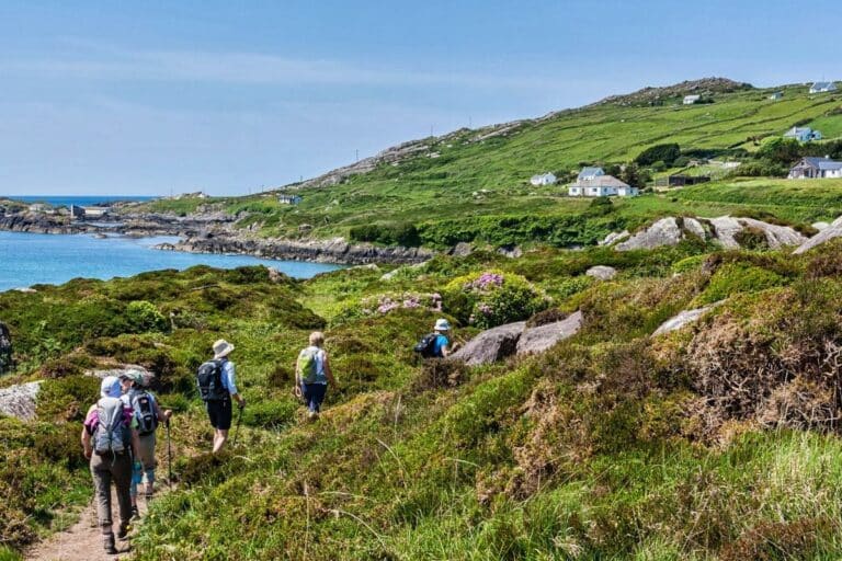 People hiking a coastal trail in Ireland – representing eco-friendly travel and sustainable adventure.